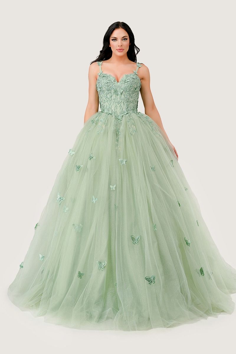 A woman wears the Light Green Quinceanera Dress 15718 by Ladivine, featuring a fitted embellished bodice and a full tulle skirt with delicate butterfly accents.